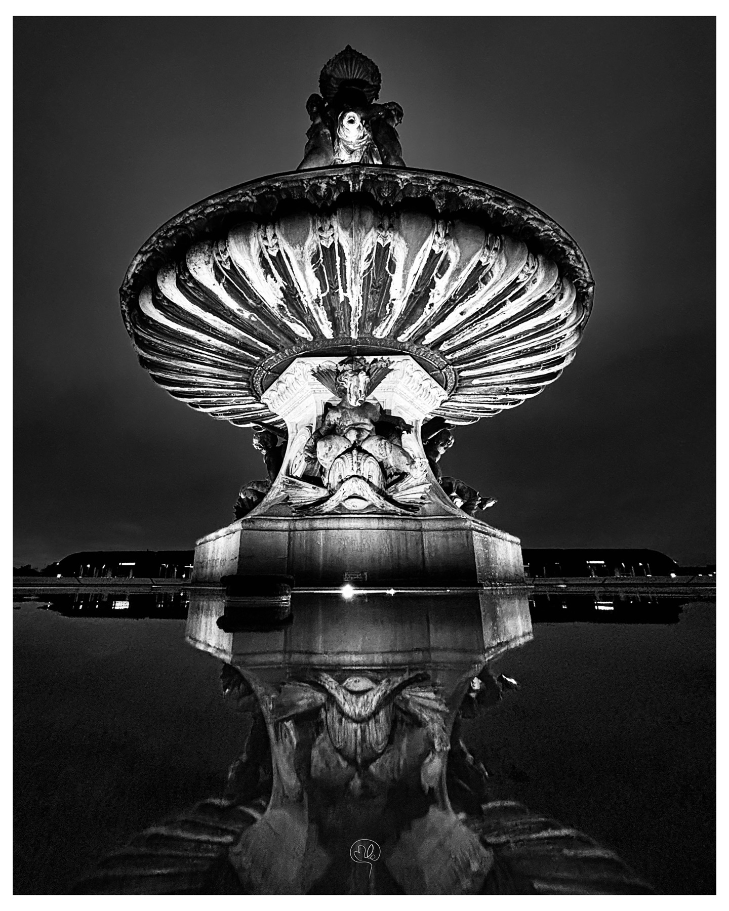A monumental basin seen from below and reflected in water